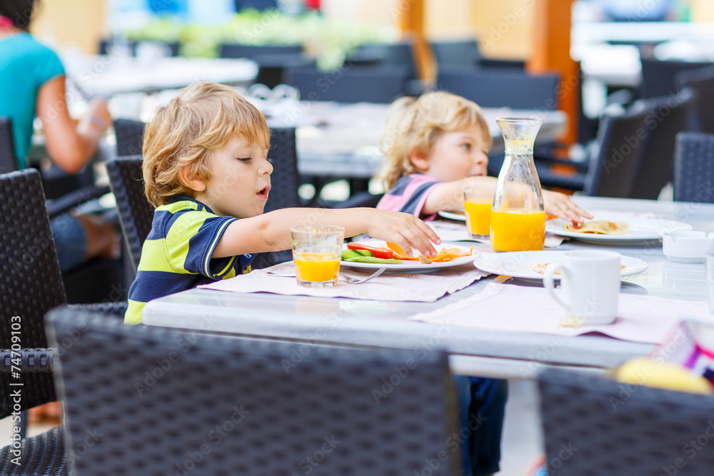 Two little kid boys having healthy breakfast in hotel restaurant Two little kid boys having healthy breakfast in hotel restaurant