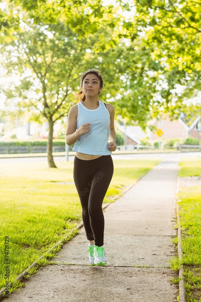 Fit young woman jogging through the park Fit young woman jogging through the park