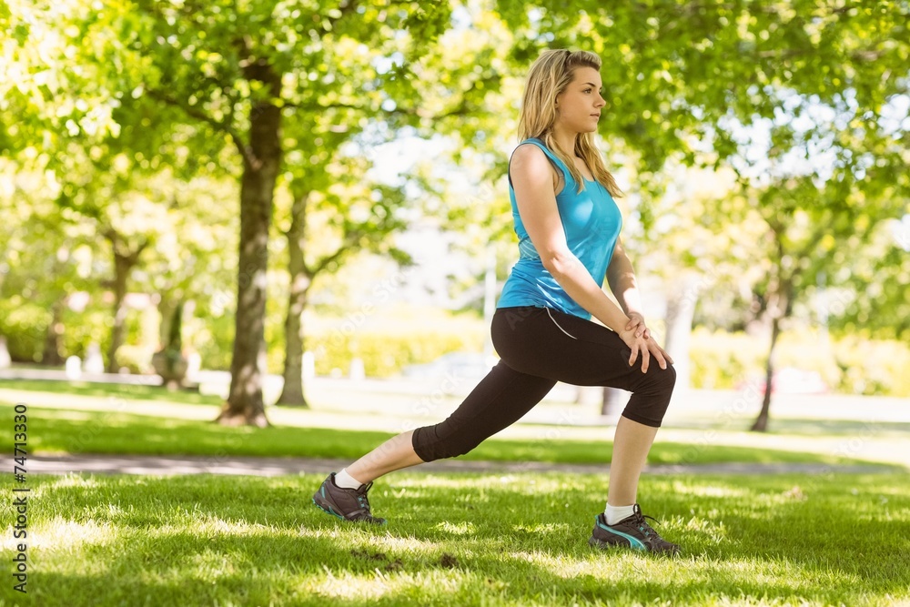 Fit blonde stretching on the grass Fit blonde stretching on the grass