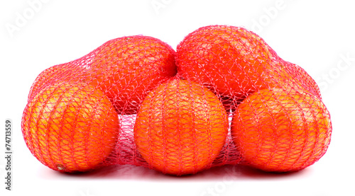 Fresh tangerines in mesh sack isolated on white background