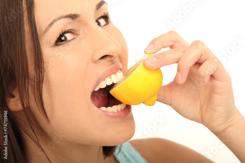 Frau beißt in eine Zitrone