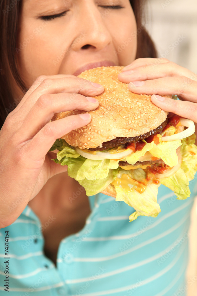 Frau beißt genüsslich in einen Burger Frau beißt genüsslich in einen Burger
