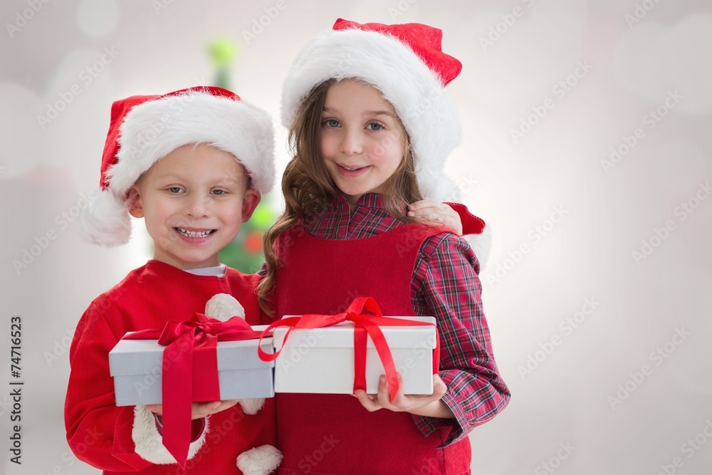 Composite image of cute siblings with gifts Composite image of cute siblings with gifts