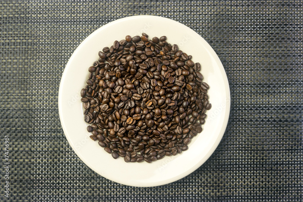 White round plate with a heap of coffee beans White round plate with a heap of coffee beans