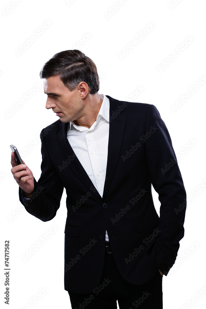 Portrait of a businessman holding smartphone and looking away Portrait of a businessman holding smartphone and looking away