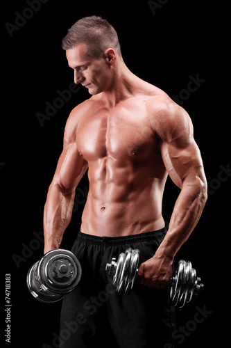 Muscular bodybuilder exercising with two weights