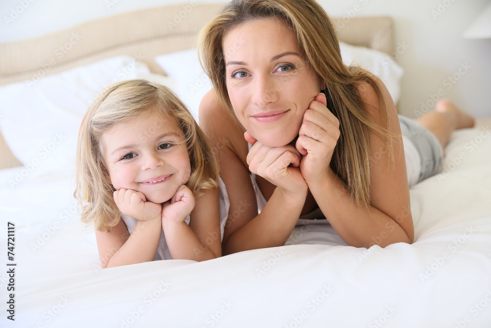 Portrait of cute little girl with mommy laying on bed Portrait of cute little girl with mommy laying on bed