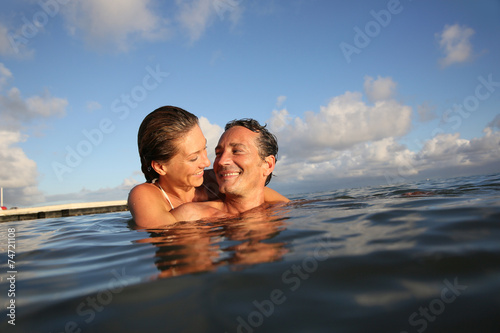 Couple swimming in sea at sunset © goodluz