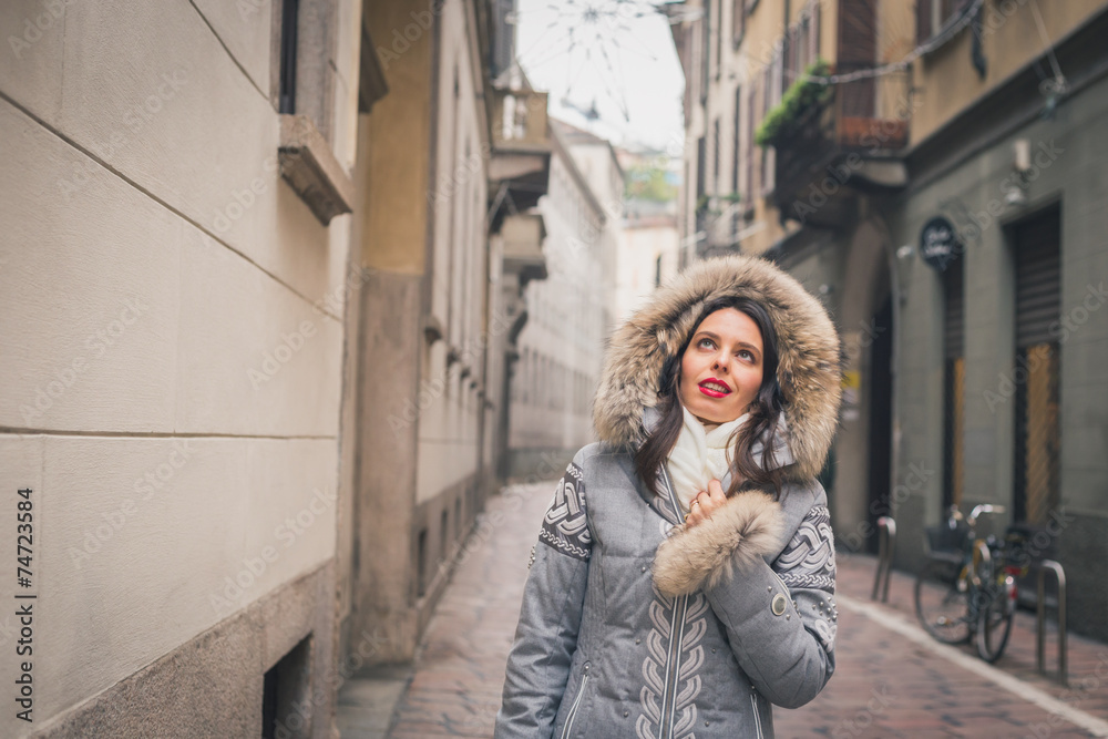 Beautiful young brunette posing in the city streets