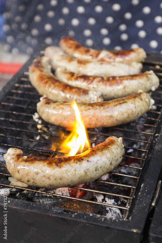 Tasty sausages cooking over the hot coals on a barbecue fire Tasty sausages cooking over the hot coals on a barbecue fire