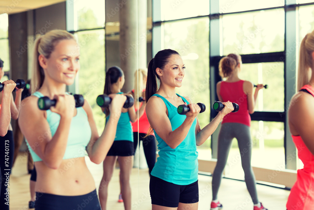 group of women with dumbbells in gym
