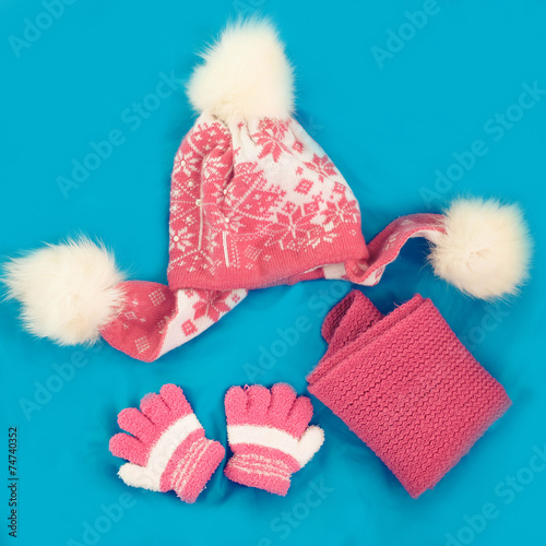 Children's cap, scarf and gloves on a blue background