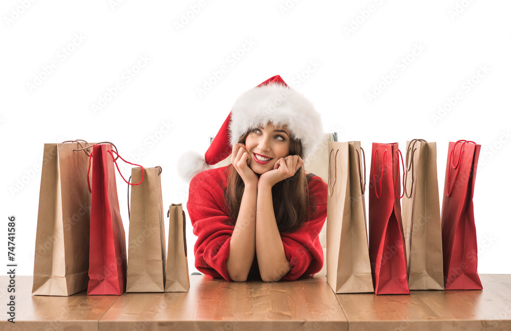 Φωτογραφία Lovely woman with shopping bags wearing Santa Claus hat dreaming