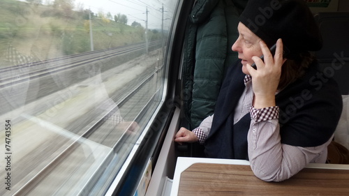 Frau telefoniert während Zugfahrt photo