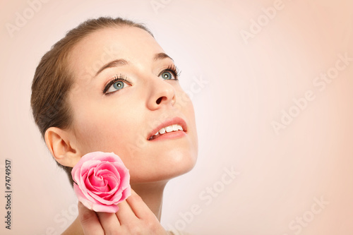 Young woman with beautiful skin holding a rose