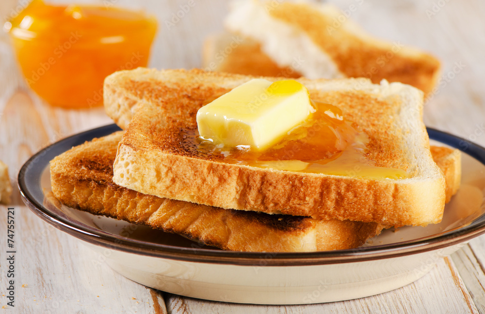 Slices toast bread fresh orange jam on a wooden background .