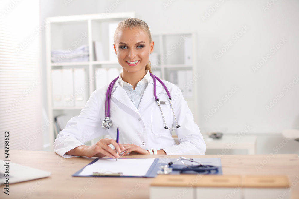 Beautiful young smiling female doctor sitting at the desk and Beautiful young smiling female doctor sitting at the desk and