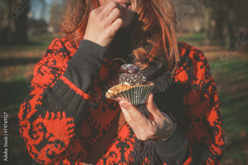 Woman in park with cupcake