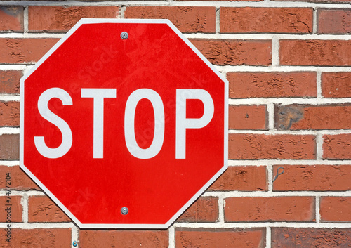 Bright stop sign on a red brick background