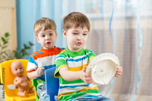 kids boys playing role game and riding on carriages made from