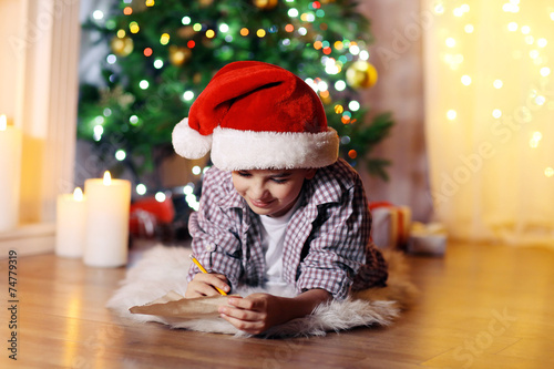 Little boy sitting near fir...