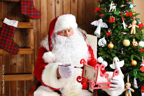 Santa Claus sitting in comfortable rocking chair and decorated