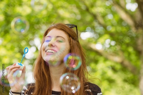 Woman blowing bubbles at park