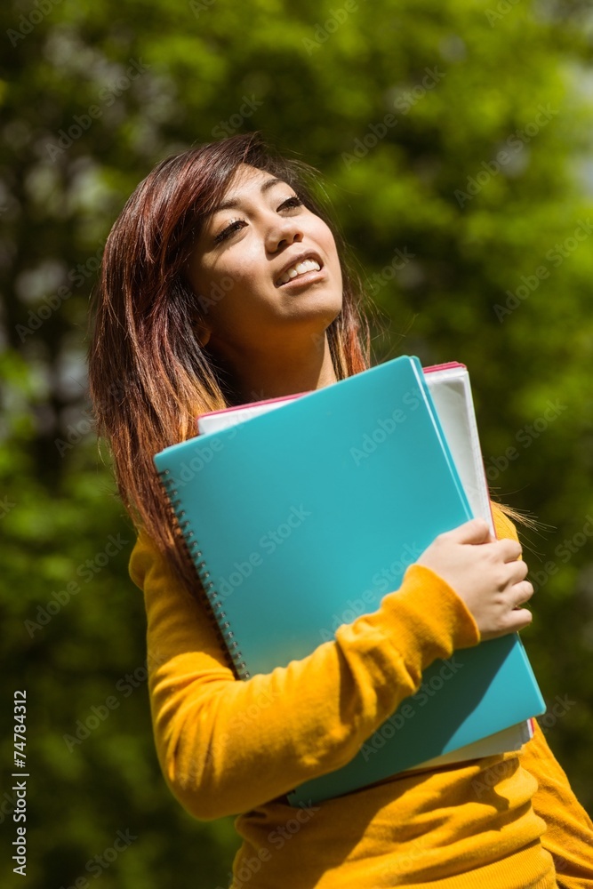 Female college student with books in park Female college student with books in park