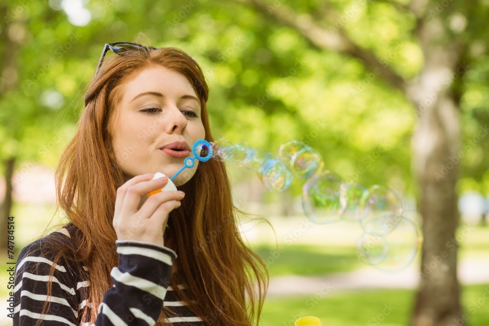 Woman blowing bubbles at park