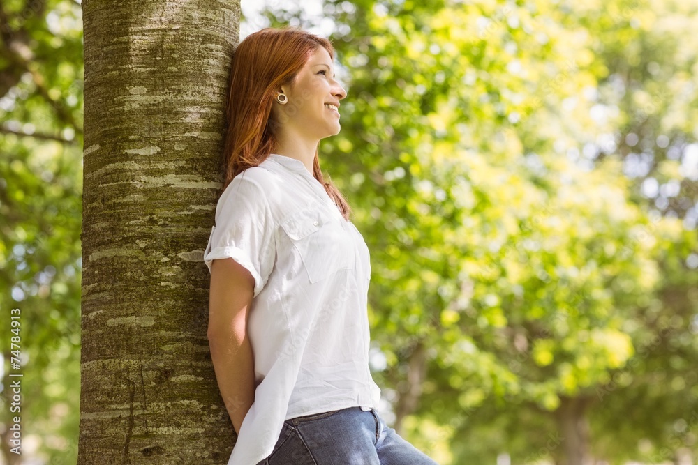Portrait of a pretty redhead leaning against trunk Portrait of a pretty redhead leaning against trunk
