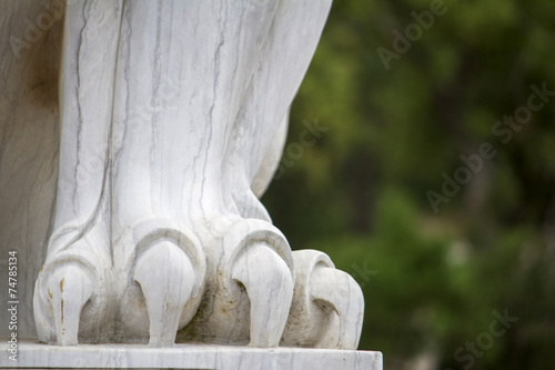 Close up view of a beautiful lion paw statue on a park. photo