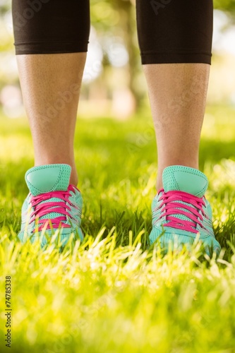Woman in running shoes standing on grass