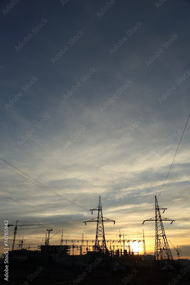 silhouette of construction and power lines at sunset