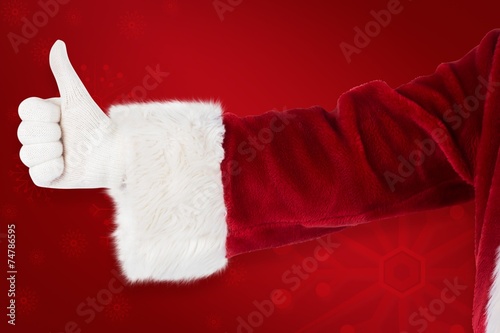 Composite image of father christmas gives a thumb up