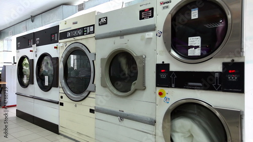 View of running washing machines in laundry room