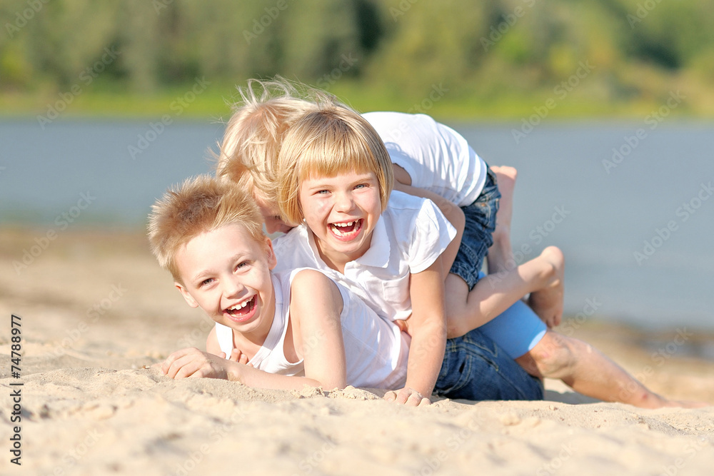 Portrait of three children playing on the beach