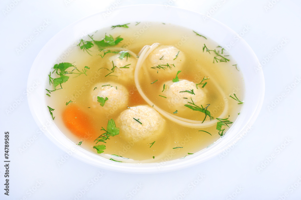 Soup with meatballs and noodles in bowl isolated on white