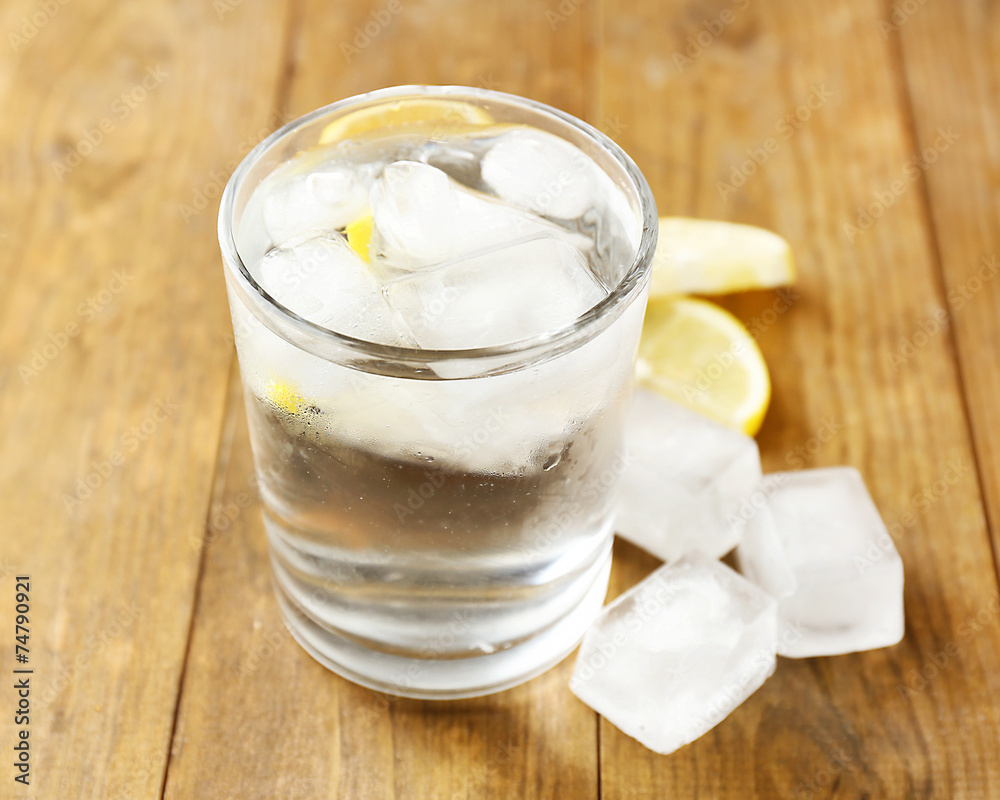 Glass of water with ice cubes on wooden table Glass of water with ice cubes on wooden table