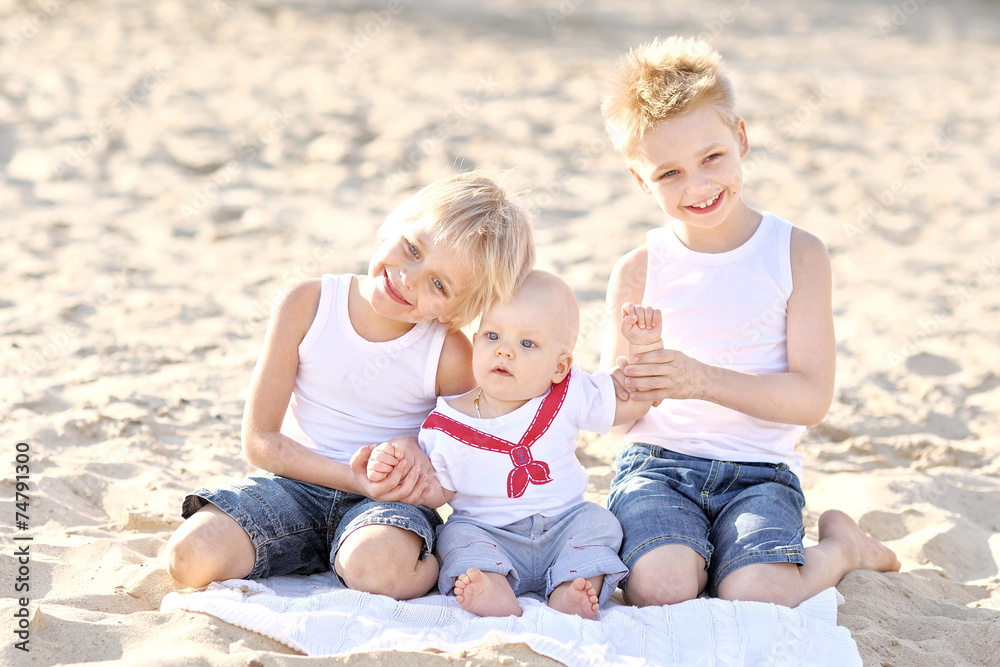 portrait of three little boys on the beach in summer