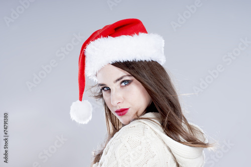 Christmas woman. Beautiful charming girl wearing  santa hat over