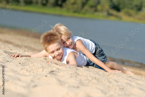 portrait of two little boys on the beach in summer © zagorodnaya