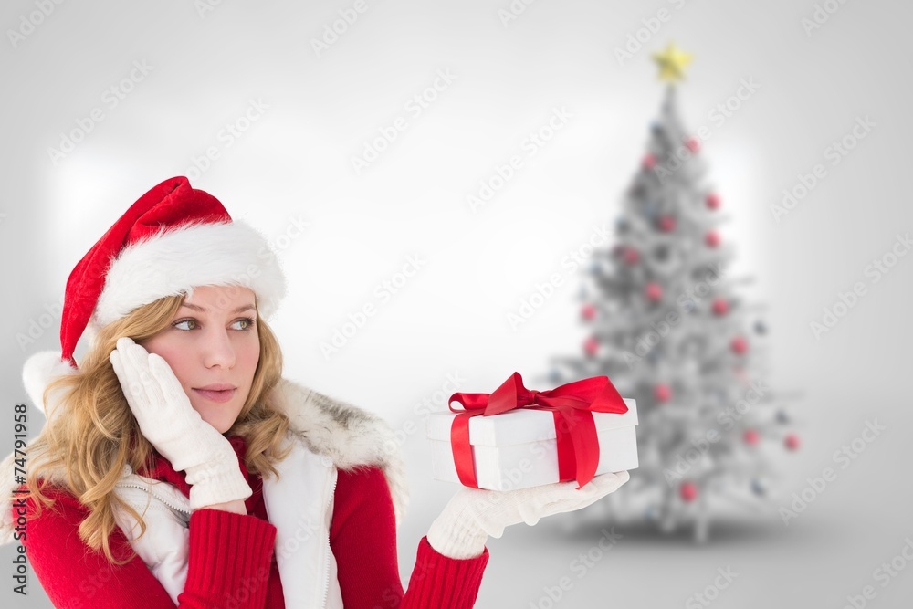 Composite image of pretty woman holding gift in a hand Composite image of pretty woman holding gift in a hand