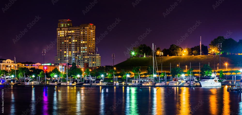 Fototapeta premium A marina and Federal Hill at night at the Inner Harbor in Baltim