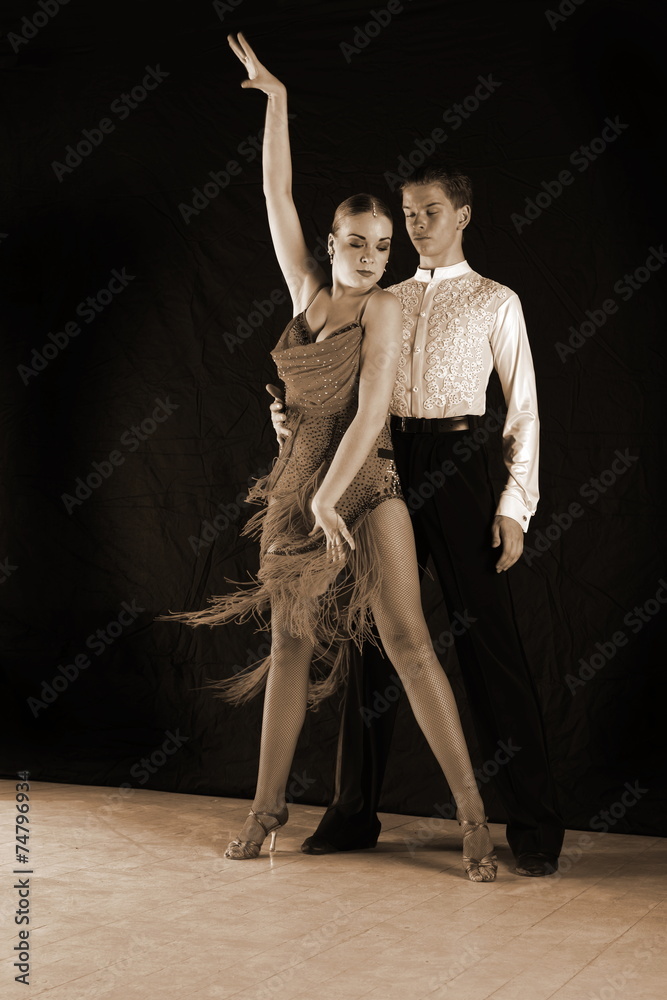 dancers in ballroom against black background