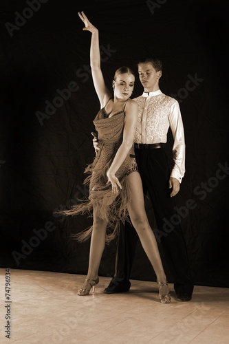 dancers in ballroom against black background