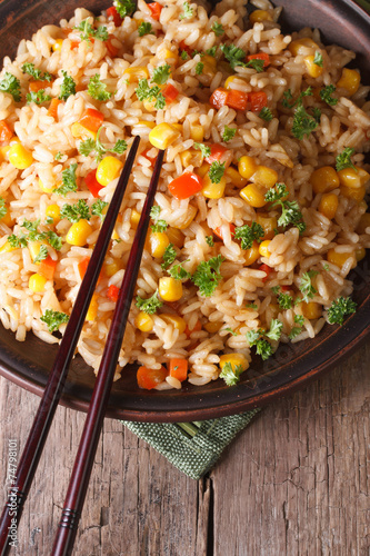 fried rice with eggs, corn and spices and chopsticks