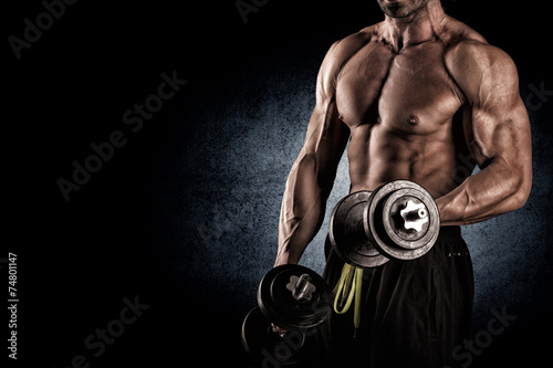 Closeup of a muscular young man lifting weights