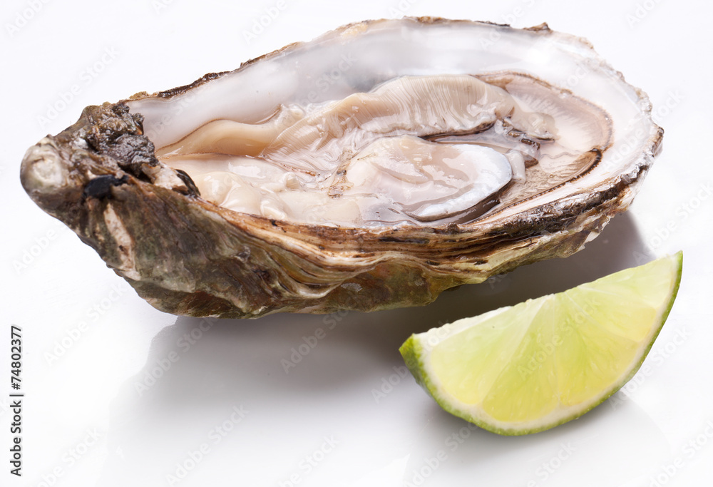 Raw oyster and lemon on a whte background. Raw oyster and lemon on a whte background.
