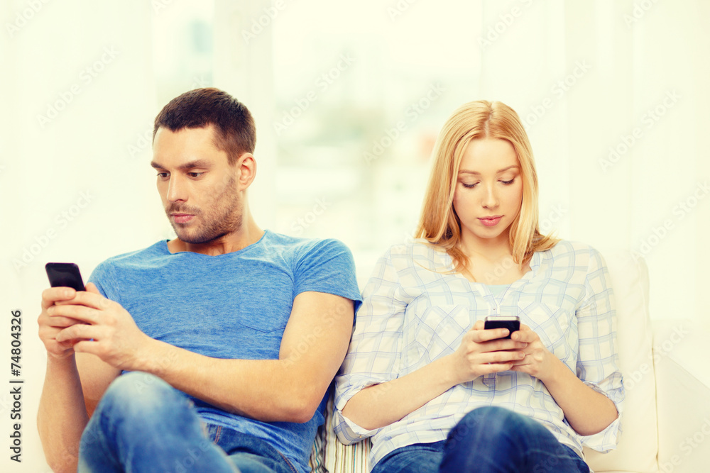 concentrated couple with smartphones at home concentrated couple with smartphones at home