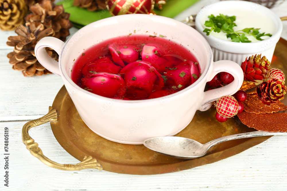 Traditional polish clear red borscht with dumplings in bowl